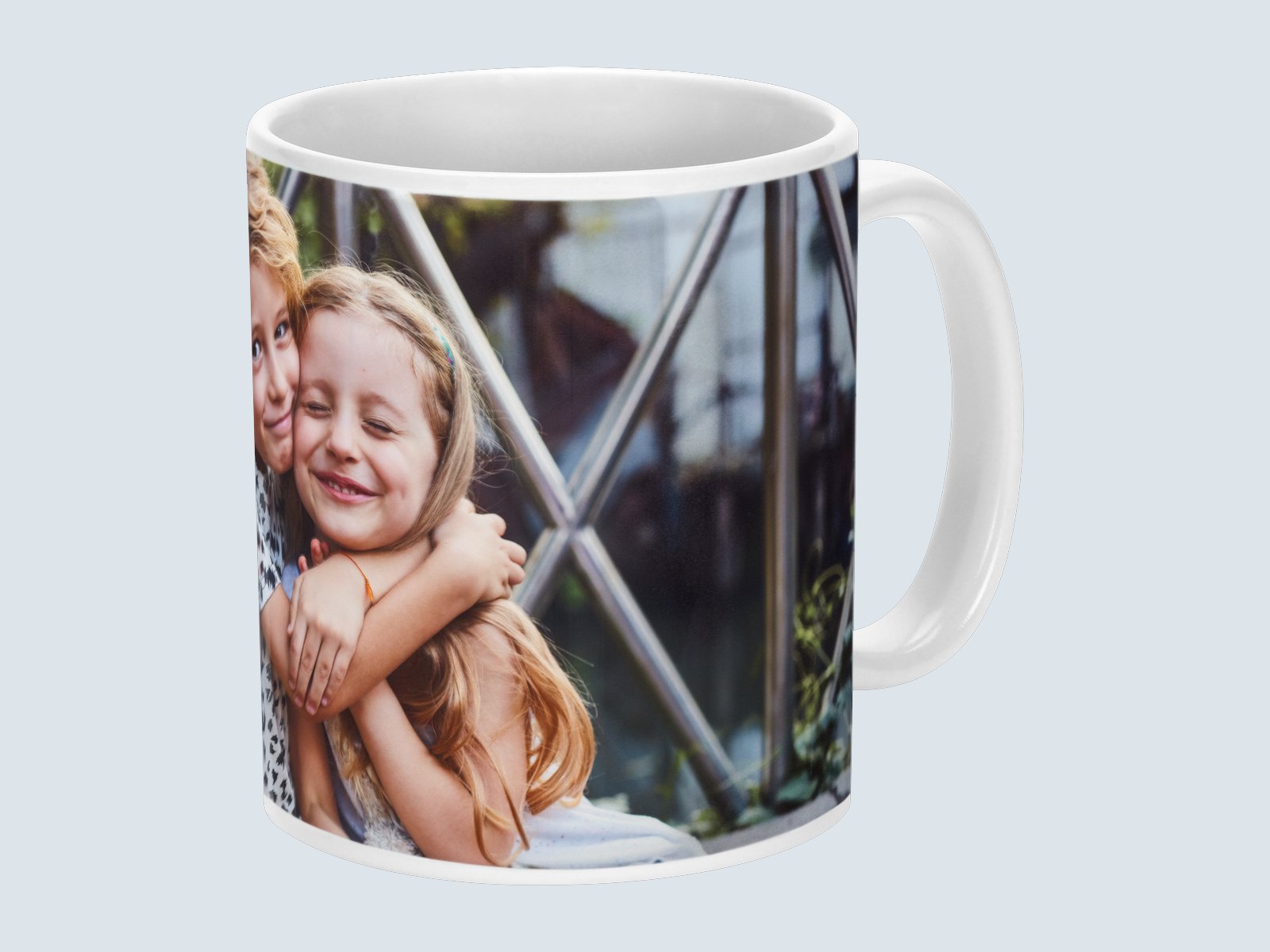 A white ceramic mug printed with a photo of two children hugging