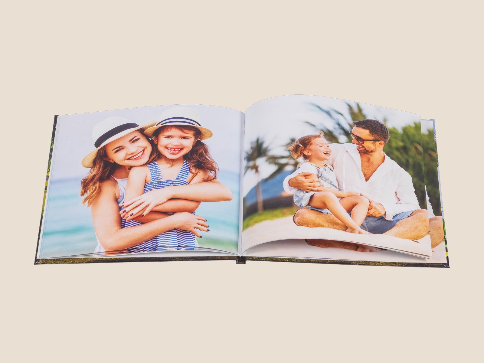 An open hardcover photo book with family beach photos across the spread