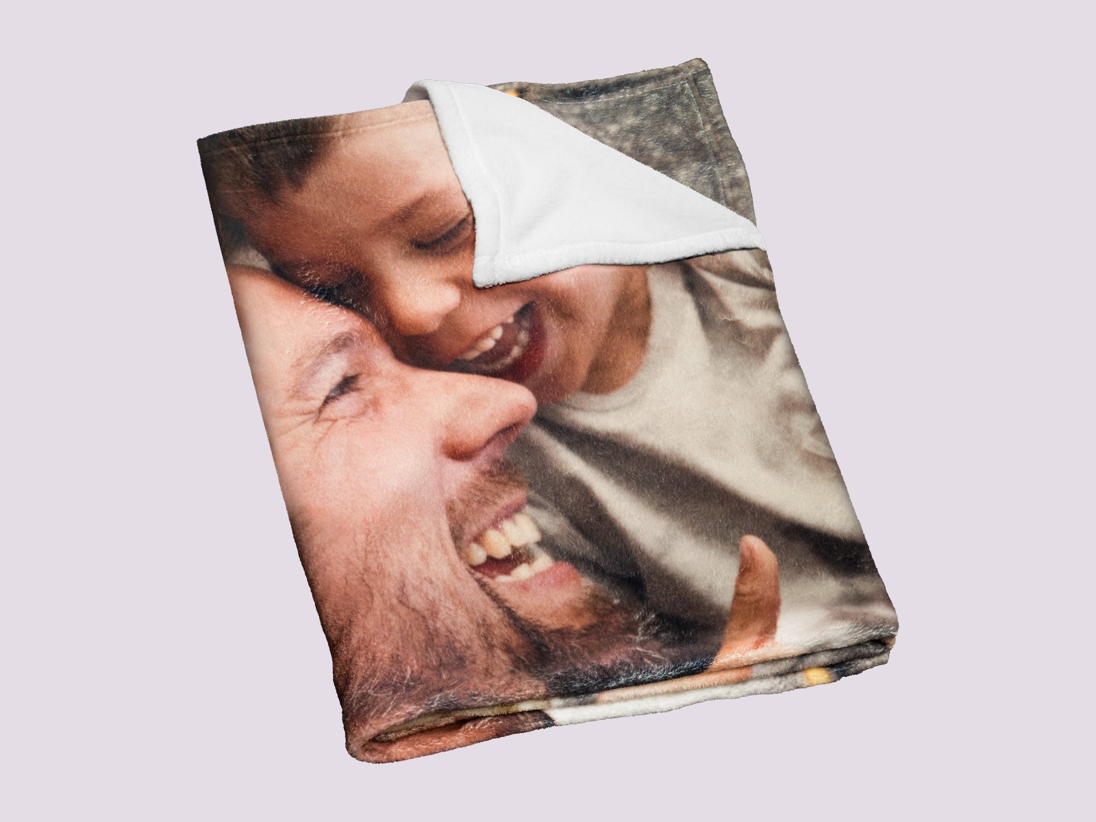 A folded fleece photo blanket with a father and son laughing