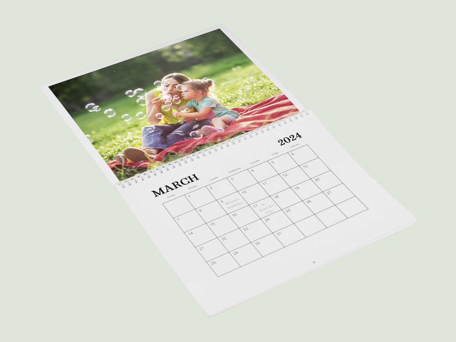 An open wall calendar with a family photo above the month grid