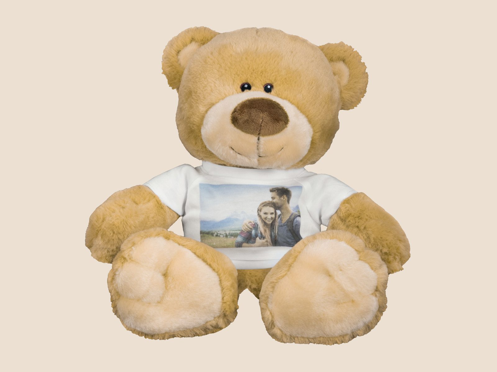 A plush teddy bear wearing a white t-shirt printed with a couple’s photo