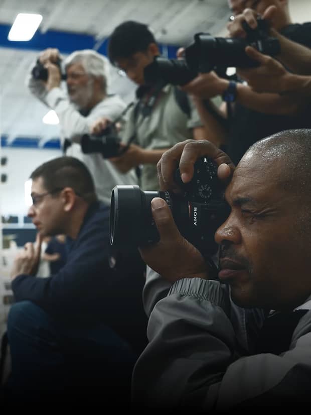 Photographers practicing with their cameras in a Unique University class