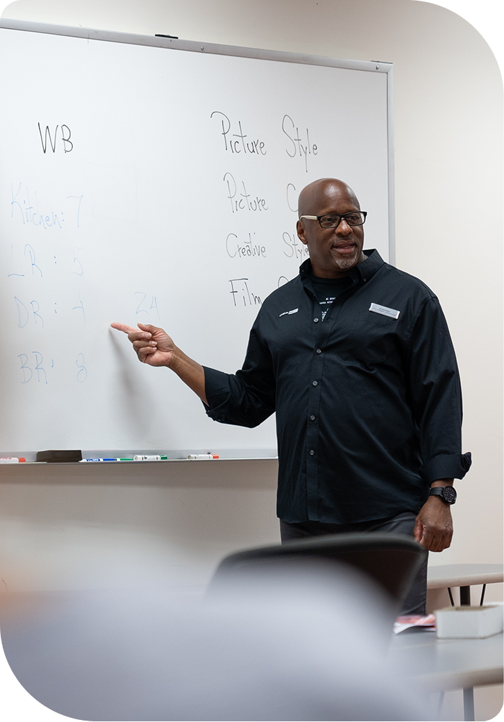 A Unique University instructor teaching at the whiteboard